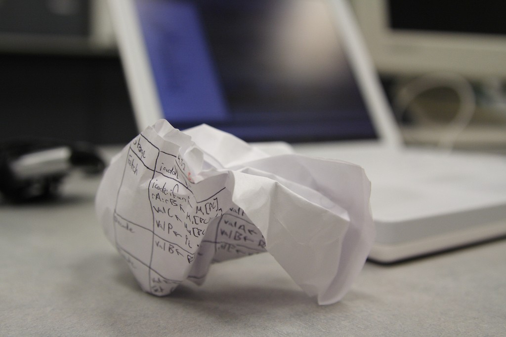 Crumpled paper with computer in the background